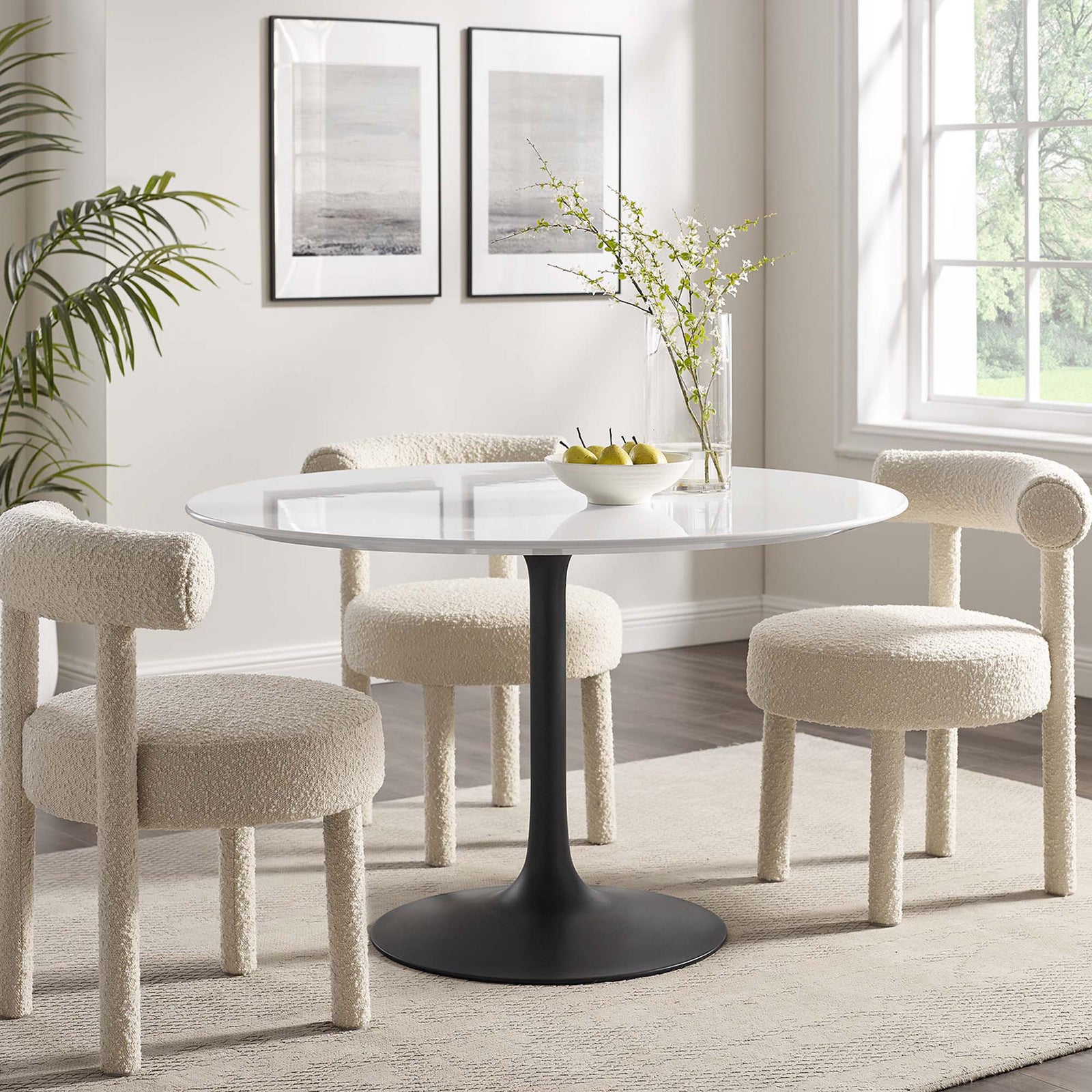 Cozy dining room with plush boucle chairs surrounding a sleek round pedestal dining table || EEI-3522-BLK-WHI || front_angle_room