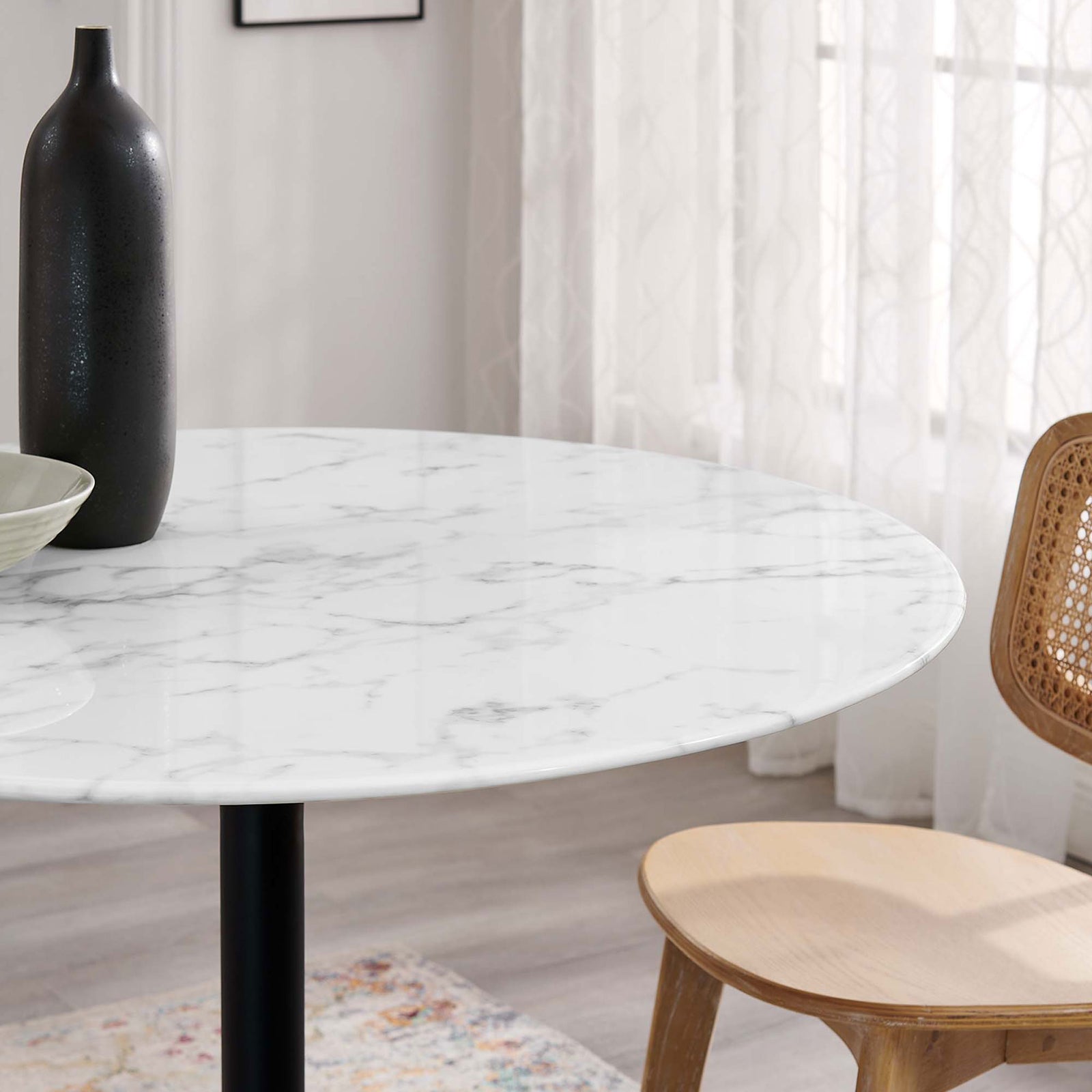 Close view of glossy faux marble tabletop beside a natural wood chair and patterned rug || EEI-3526-BLK-WHI || detail_room