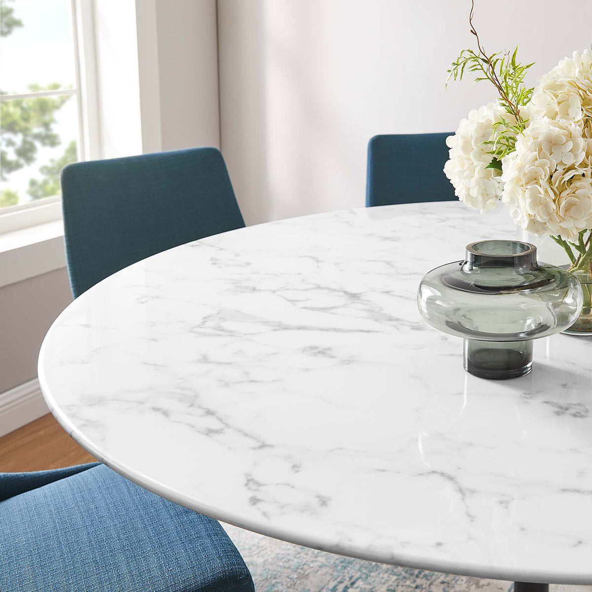 Close up of 60 inch faux marble tabletop styled with blue chairs, flowers, and a glass vase || EEI-3529-BLK-WHI || detail_room