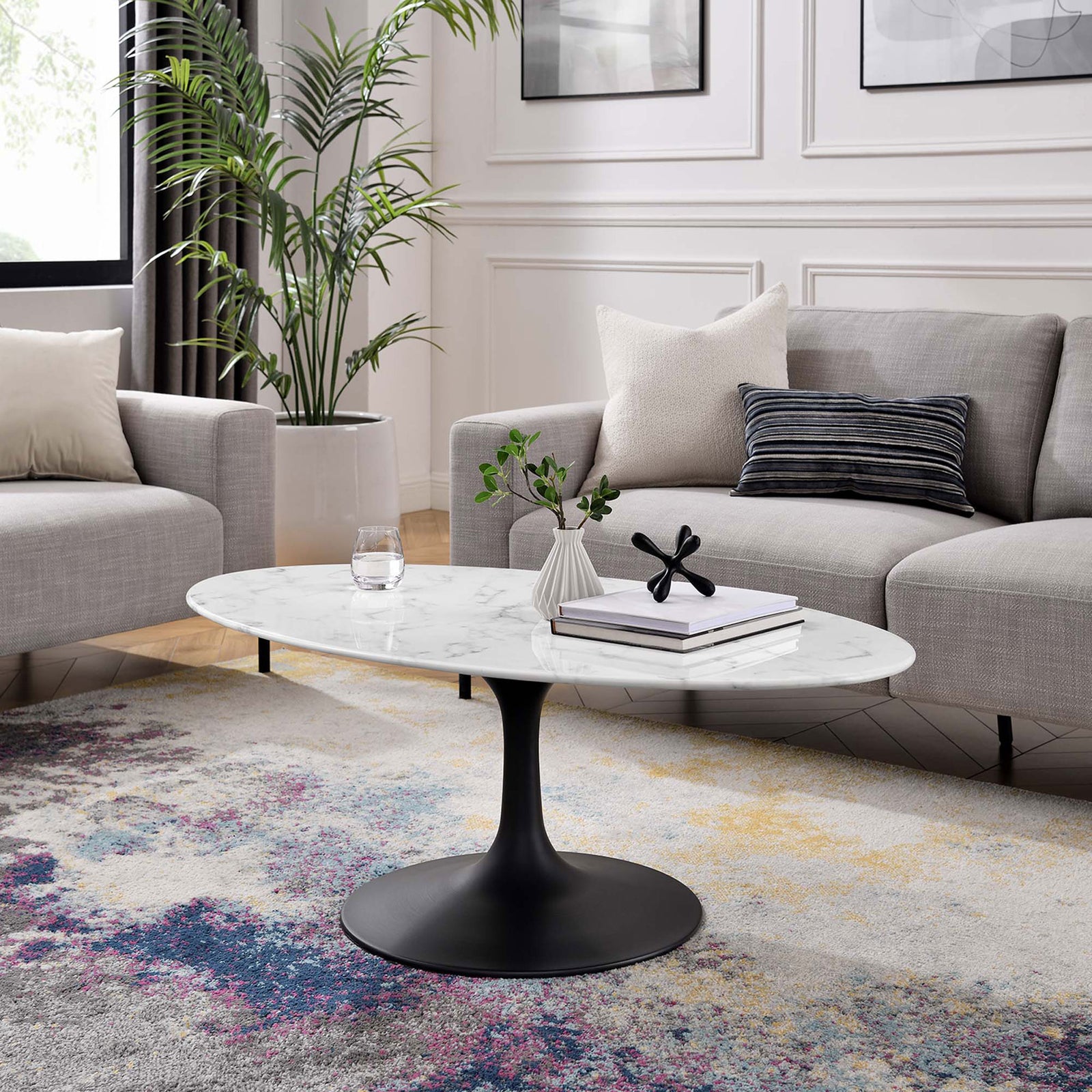 Mid-century oval coffee table anchors the living room with white faux marble and black pedestal base || EEI-3537-BLK-WHI || front_angle_room
