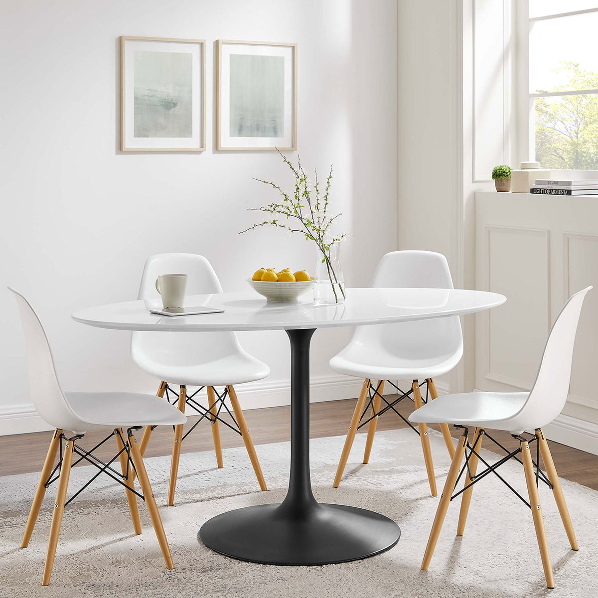 White oval pedestal dining table with black base paired with four modern chairs in a bright dining room || EEI-3539-BLK-WHI || front_angle_room