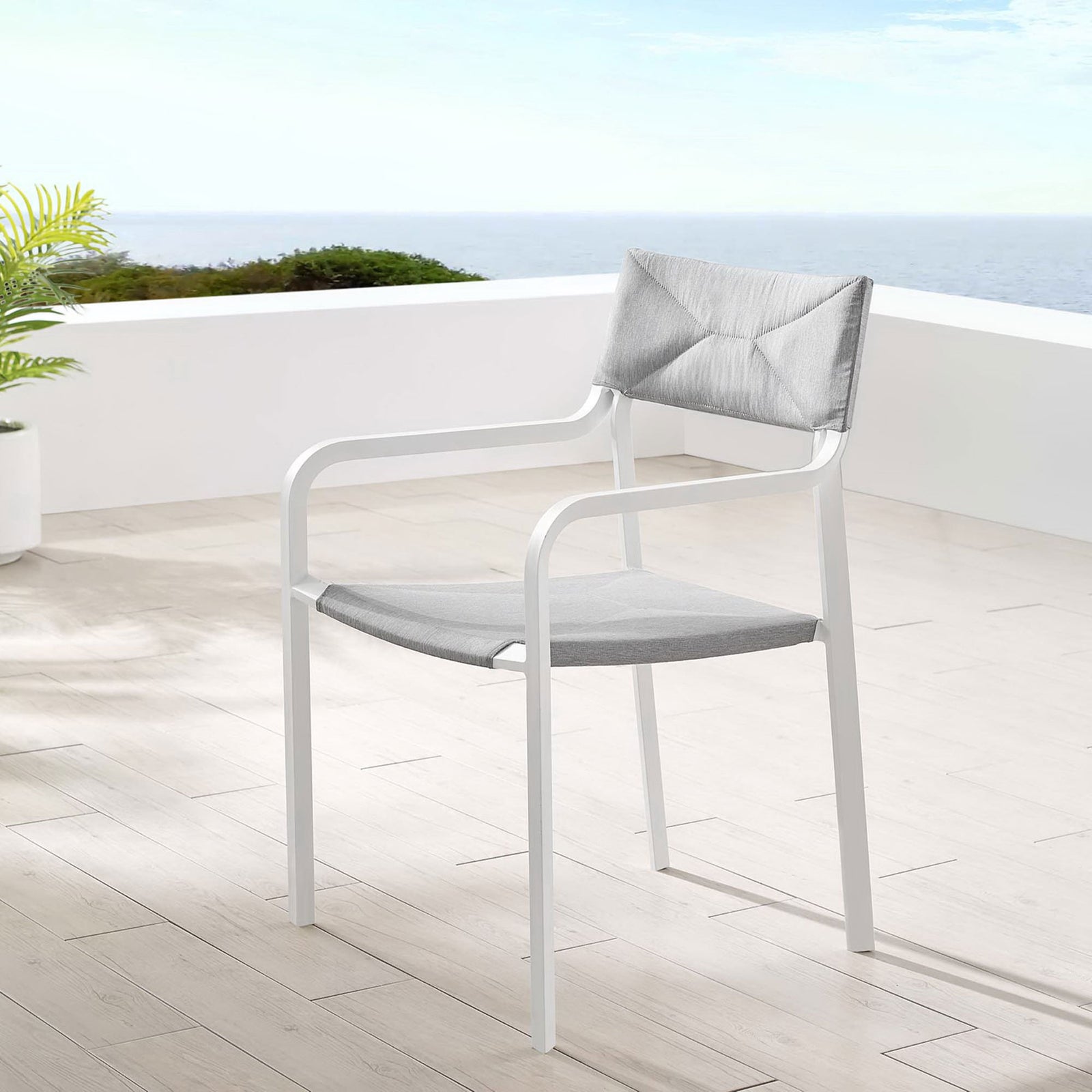 Single gray and white patio armchair on a bright coastal balcony with wood plank flooring || EEI-3573-WHI-GRY || front_angle_room