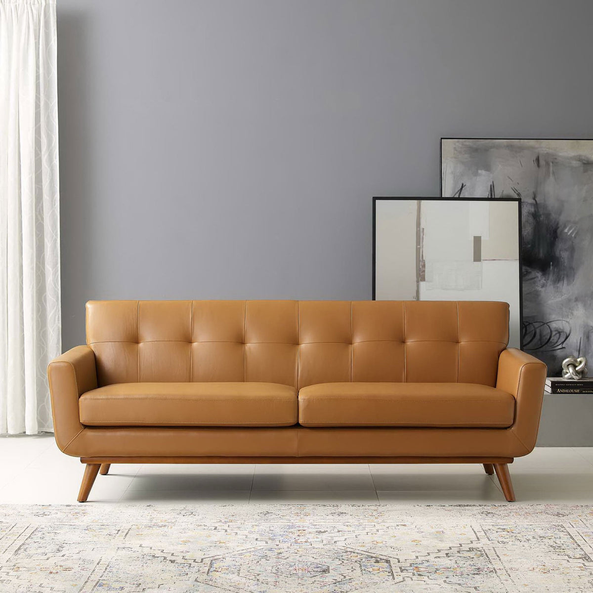 Tan leather mid-century sofa styled in a modern living room with artwork and neutral rug || EEI-3733-TAN || front_room