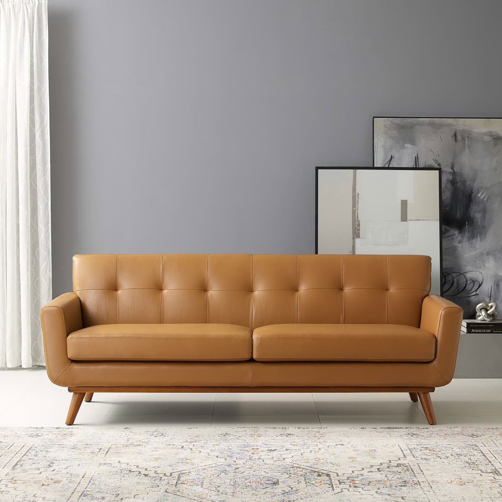 Tan leather mid-century sofa styled in a modern living room with artwork and neutral rug || EEI-3733-TAN || front_room