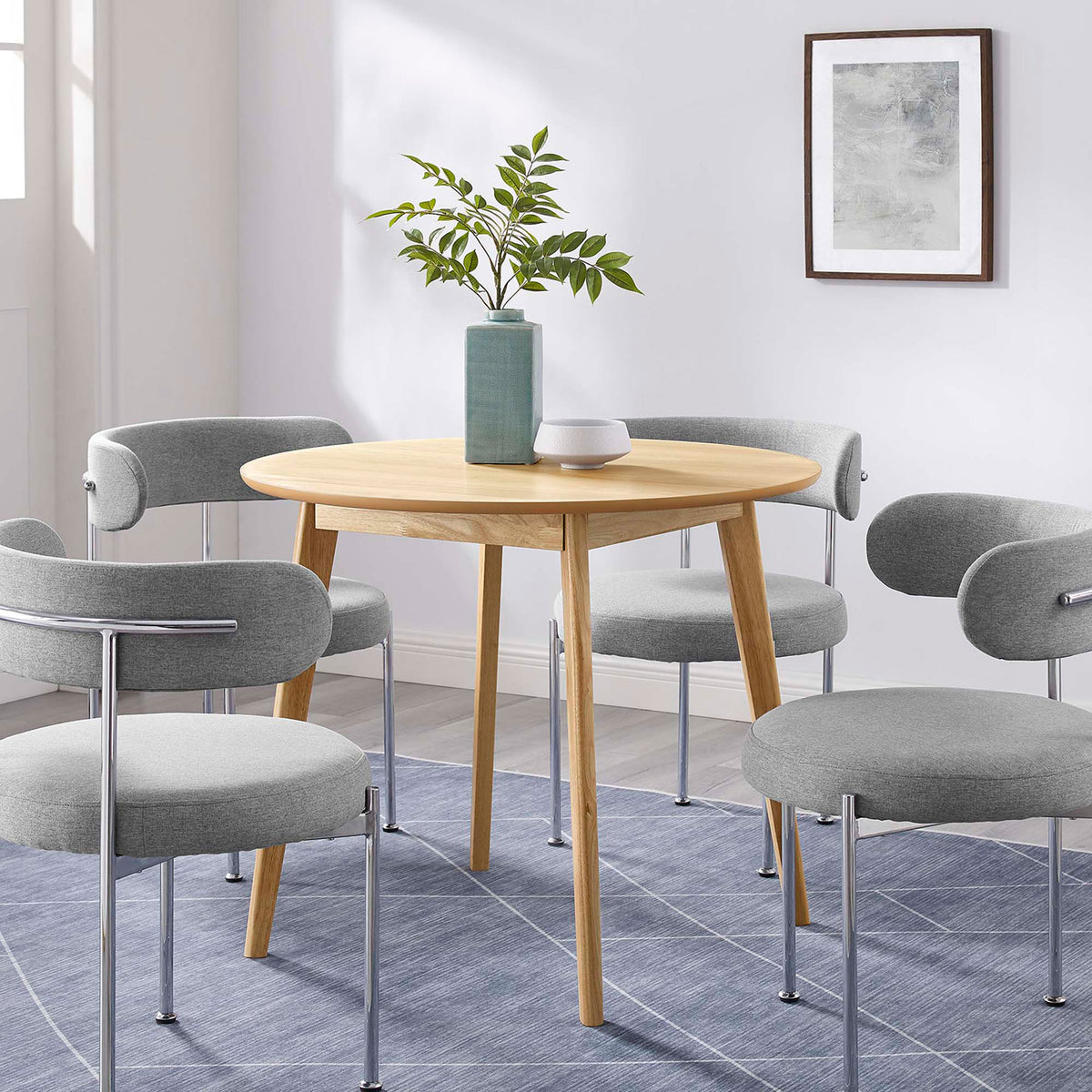 Round oak dining table paired with four gray chairs to create a bright, modern breakfast nook || EEI-3749-OAK || front_angle_room