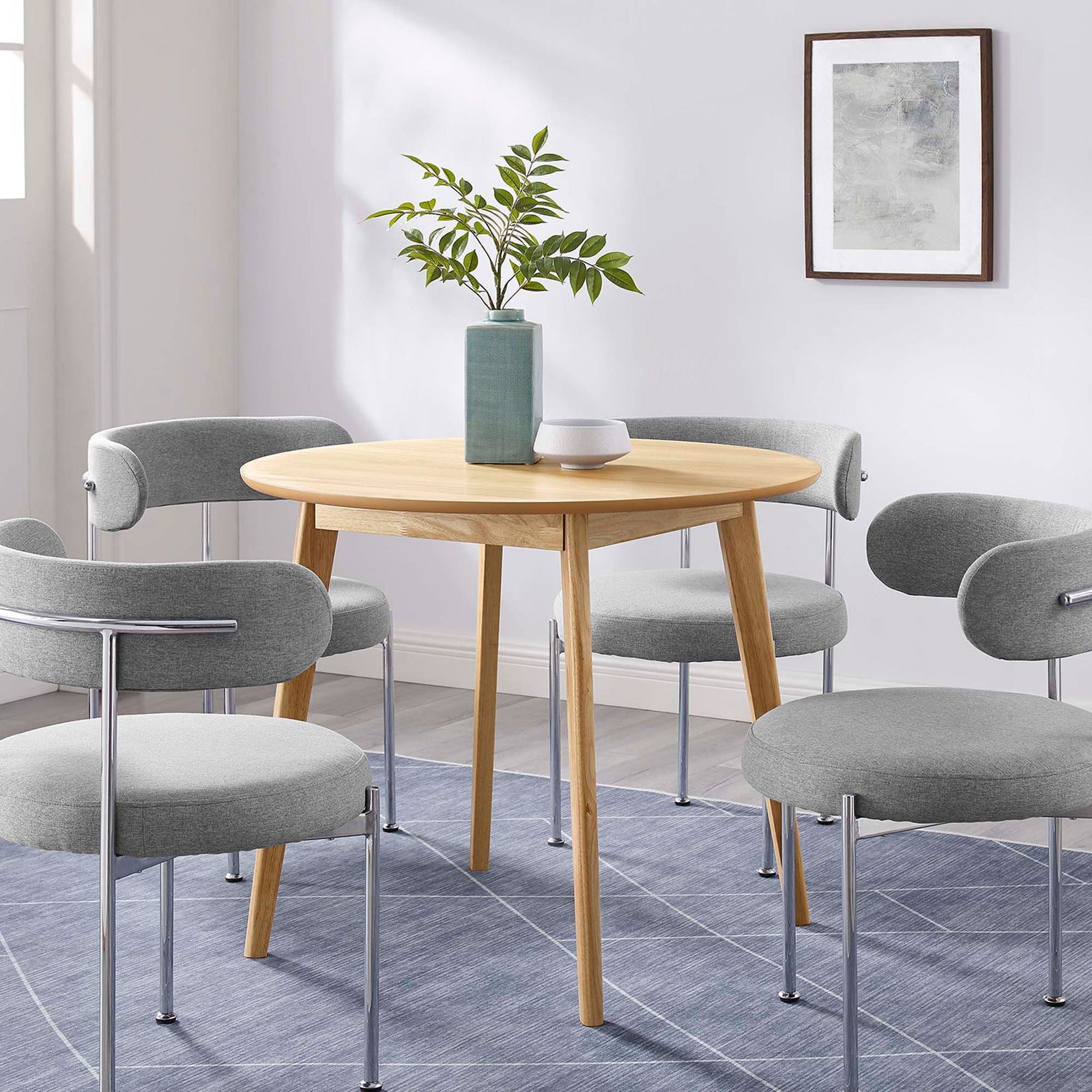 Round oak dining table paired with four gray chairs to create a bright, modern breakfast nook || EEI-3749-OAK || front_angle_room