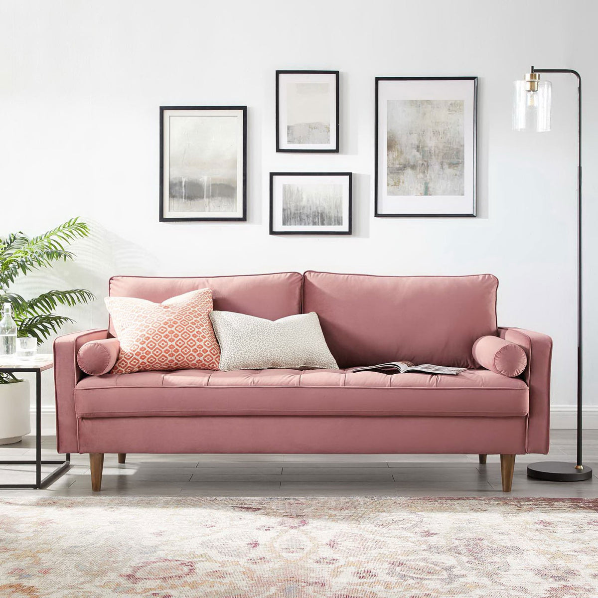 Dusty rose velvet sofa with tufted seat and bolster pillows styled in a modern living room with artwork and floor lamp || EEI-3764-DUS || front_angle_room