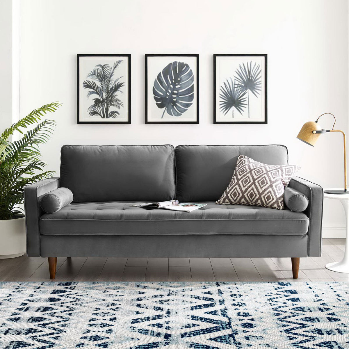 Gray velvet sofa with bolster and accent pillows styled in a bright modern living room || EEI-3764-GRY || front_room