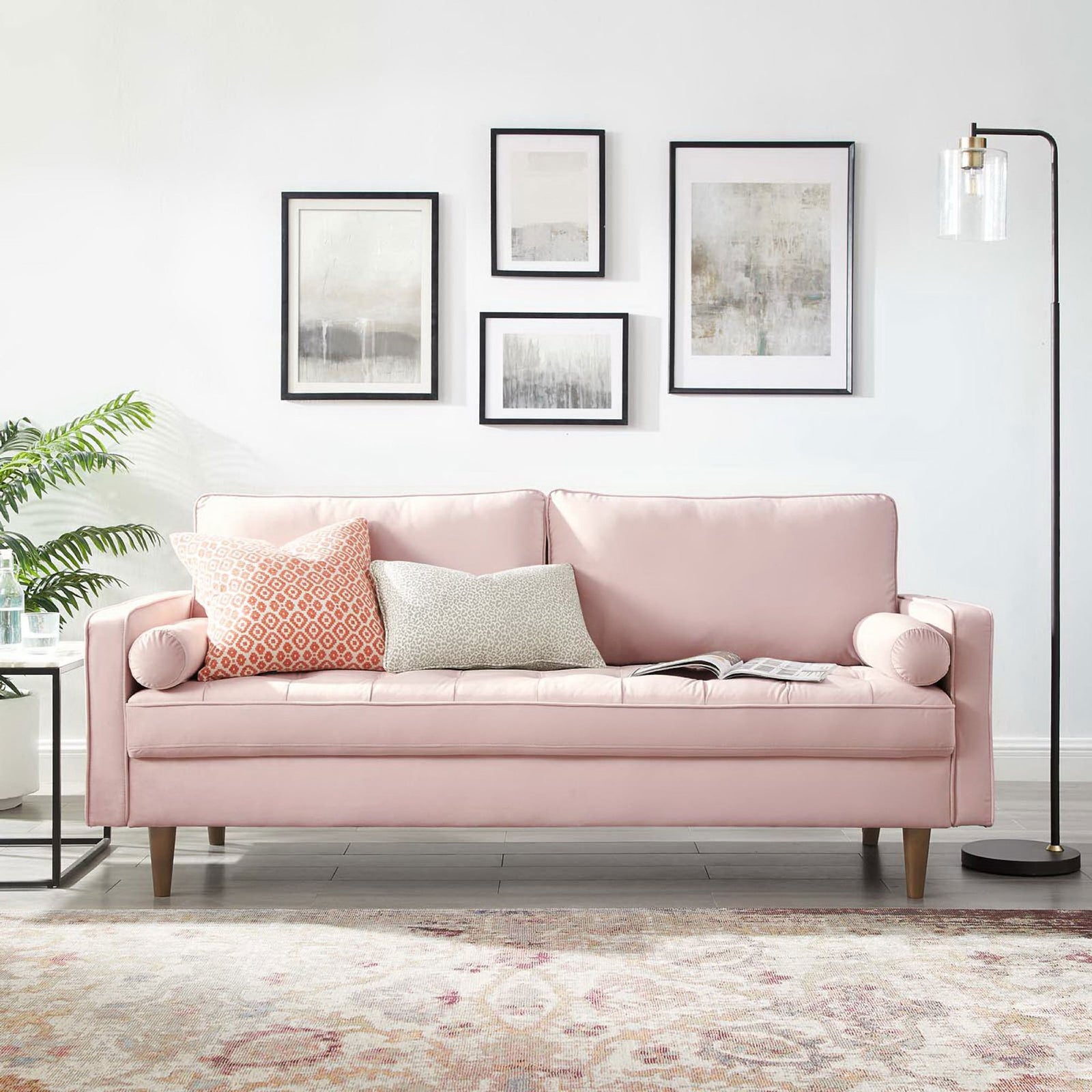 Valour pink velvet sofa styled in a modern living room with accent pillows, artwork, and floor lamp || EEI-3764-PNK || front_room
