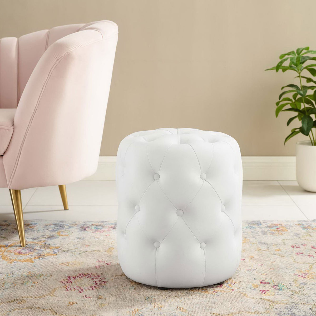 White tufted round ottoman in faux leather adding modern glam seating to a stylish living room. || EEI-3777-WHI || front_angle_room