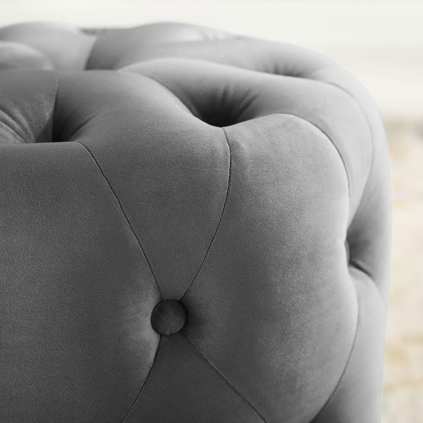 Gray velvet ottoman corner detail highlighting plush tufting against a softly styled living room backdrop || EEI-3778-GRY || detail_room