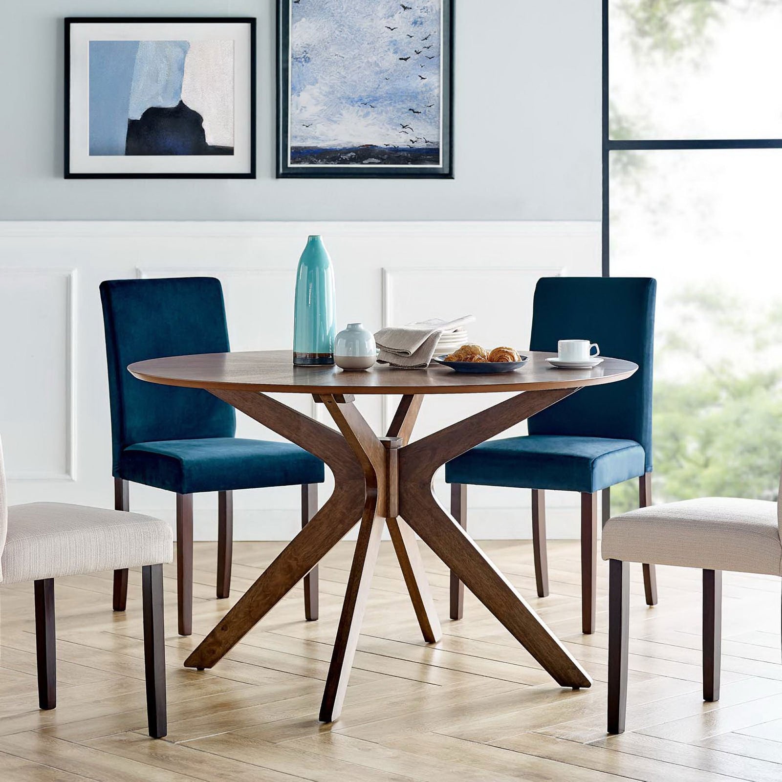Walnut round dining table anchoring a bright, airy dining room with mixed upholstered chairs || EEI-3847-WAL || front_angle_room