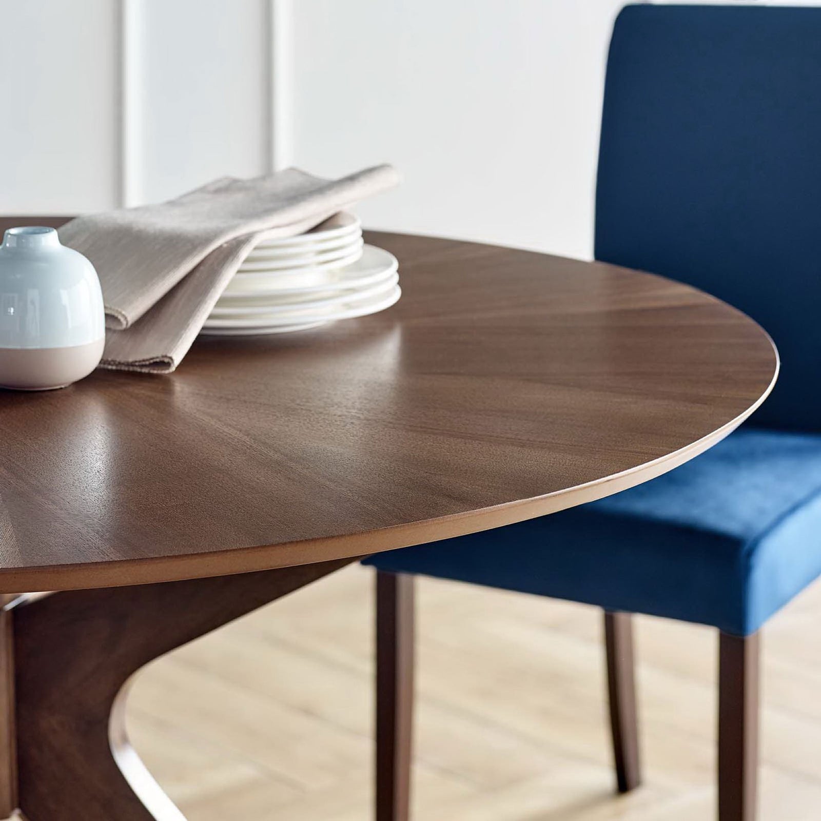 Walnut dining table top styled with plates, linen, and a blue upholstered dining chair || EEI-3847-WAL || detail_room