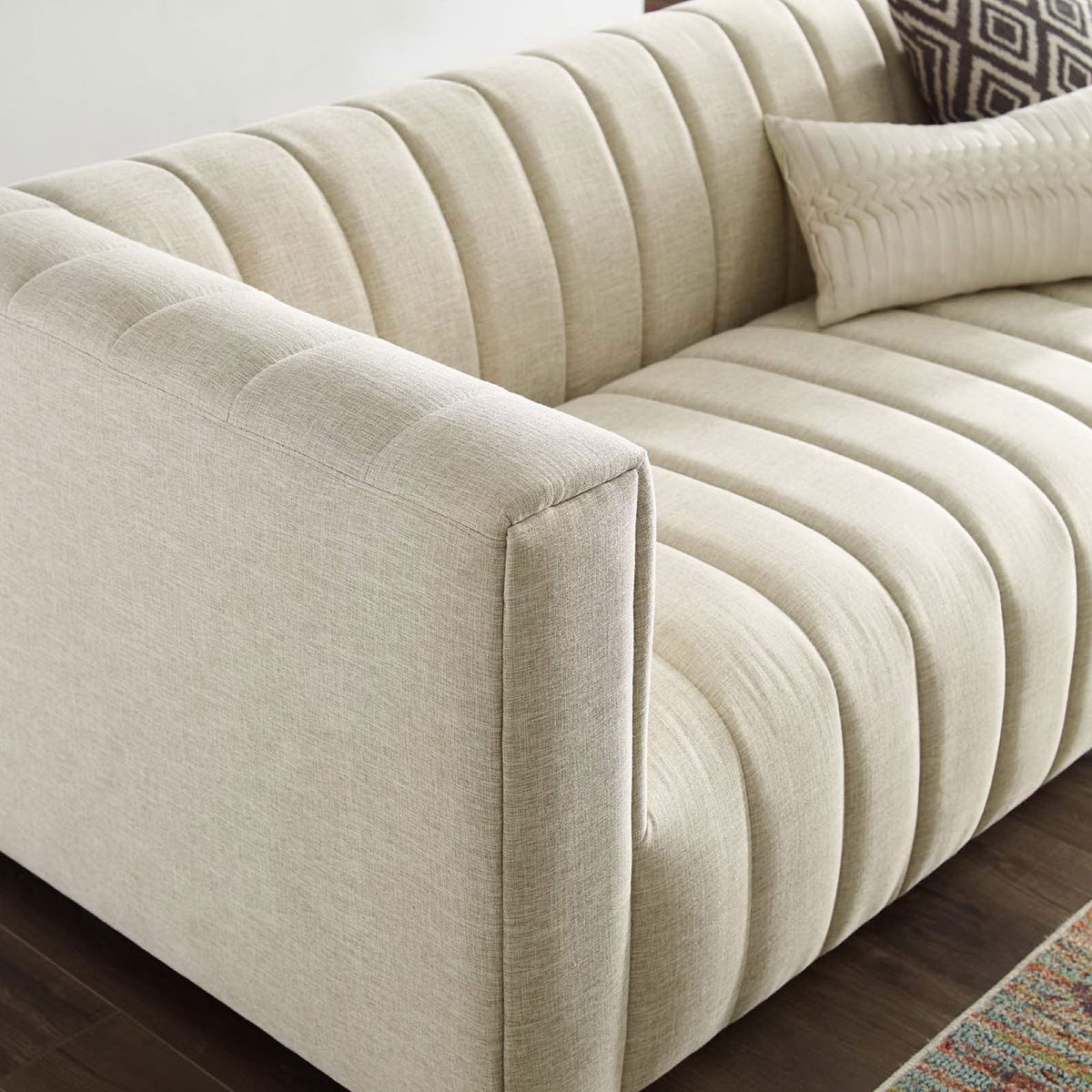 Channel tufted seat and arm in a styled living room with soft beige upholstery and accent pillows || EEI-3881-BEI || detail_room