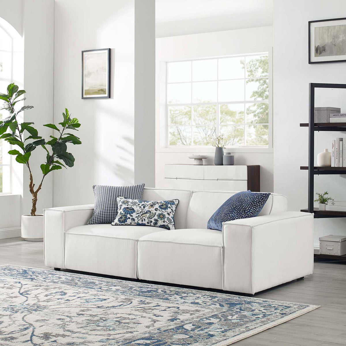 White sectional sofa styled in a bright living room with patterned pillows and area rug || EEI-4111-WHI || front_angle_room