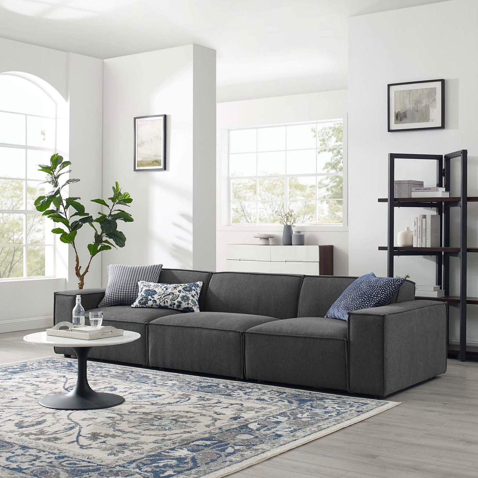 Charcoal three-piece sectional sofa styled in a bright modern living room with rug and coffee table || EEI-4112-CHA || front_angle_room