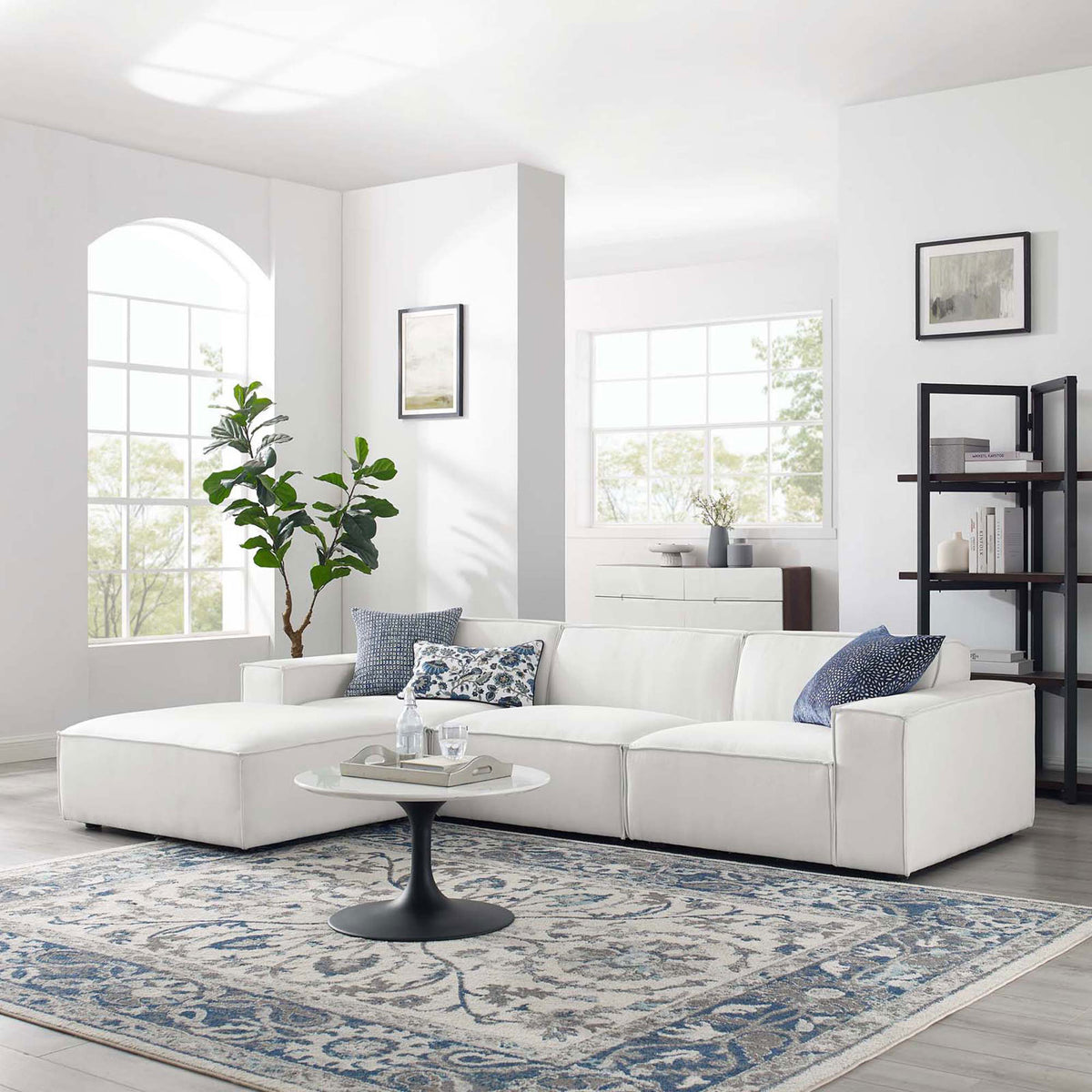 White modular sectional sofa styled in a bright living room with rug, pillows, and coffee table || EEI-4113-WHI || front_angle_room