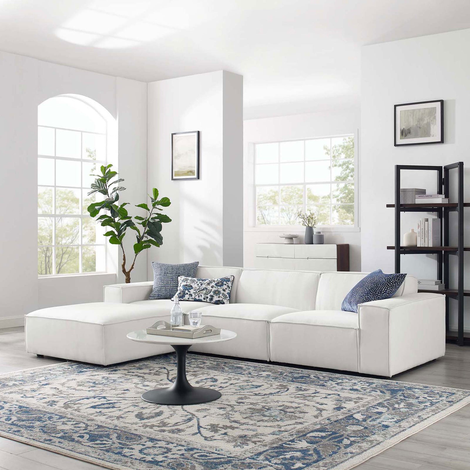 White modular sectional sofa styled in a bright living room with rug, pillows, and coffee table || EEI-4113-WHI || front_angle_room