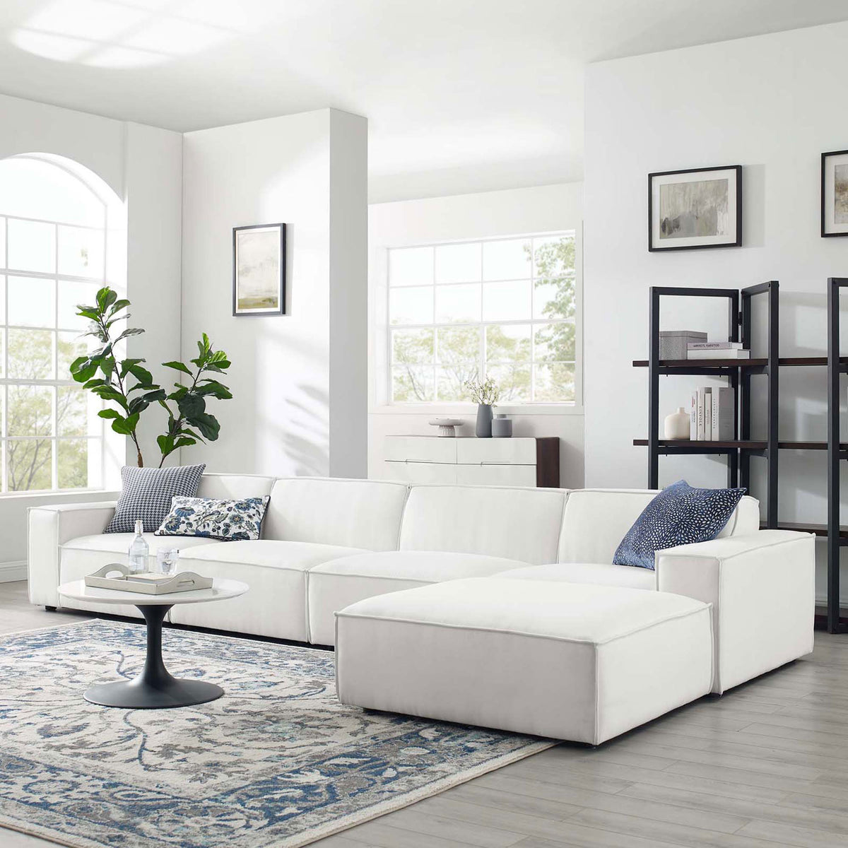 White Restore sectional arranged in a modern living room with rug, coffee table, and decor accents || EEI-4115-WHI || front_angle_room