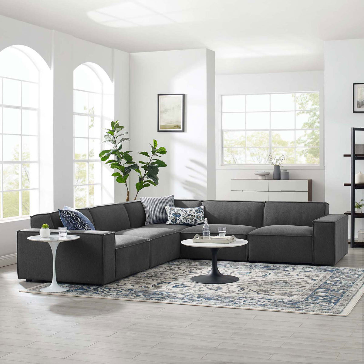 Charcoal modular sectional styled in a bright living room with rug, accent tables, and patterned pillows || EEI-4117-CHA || front_angle_room