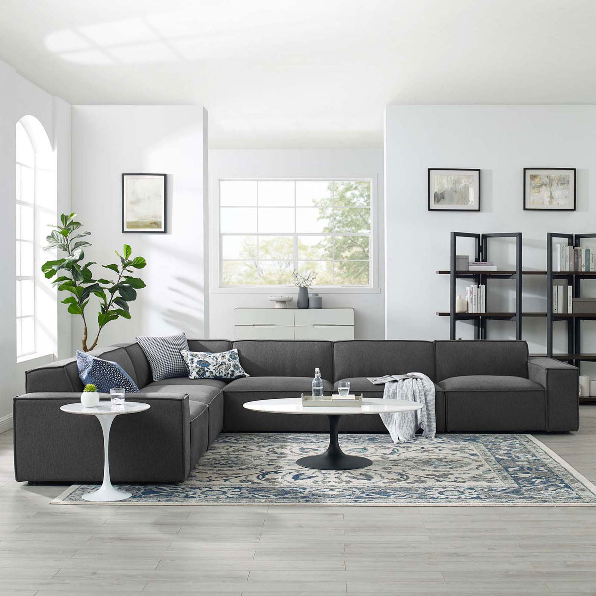 Charcoal modular sectional styled in a spacious living room with accent pillows, rug, and modern tables || EEI-4119-CHA || front_angle_room