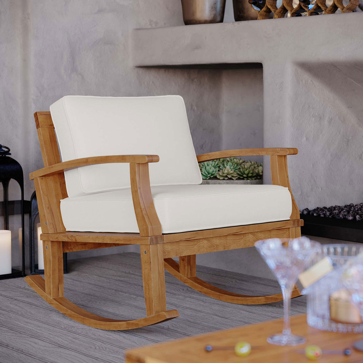 Marina teak rocking chair with white cushions styled on a covered patio for breezy outdoor relaxation || EEI-4177-NAT-WHI || front_angle_room