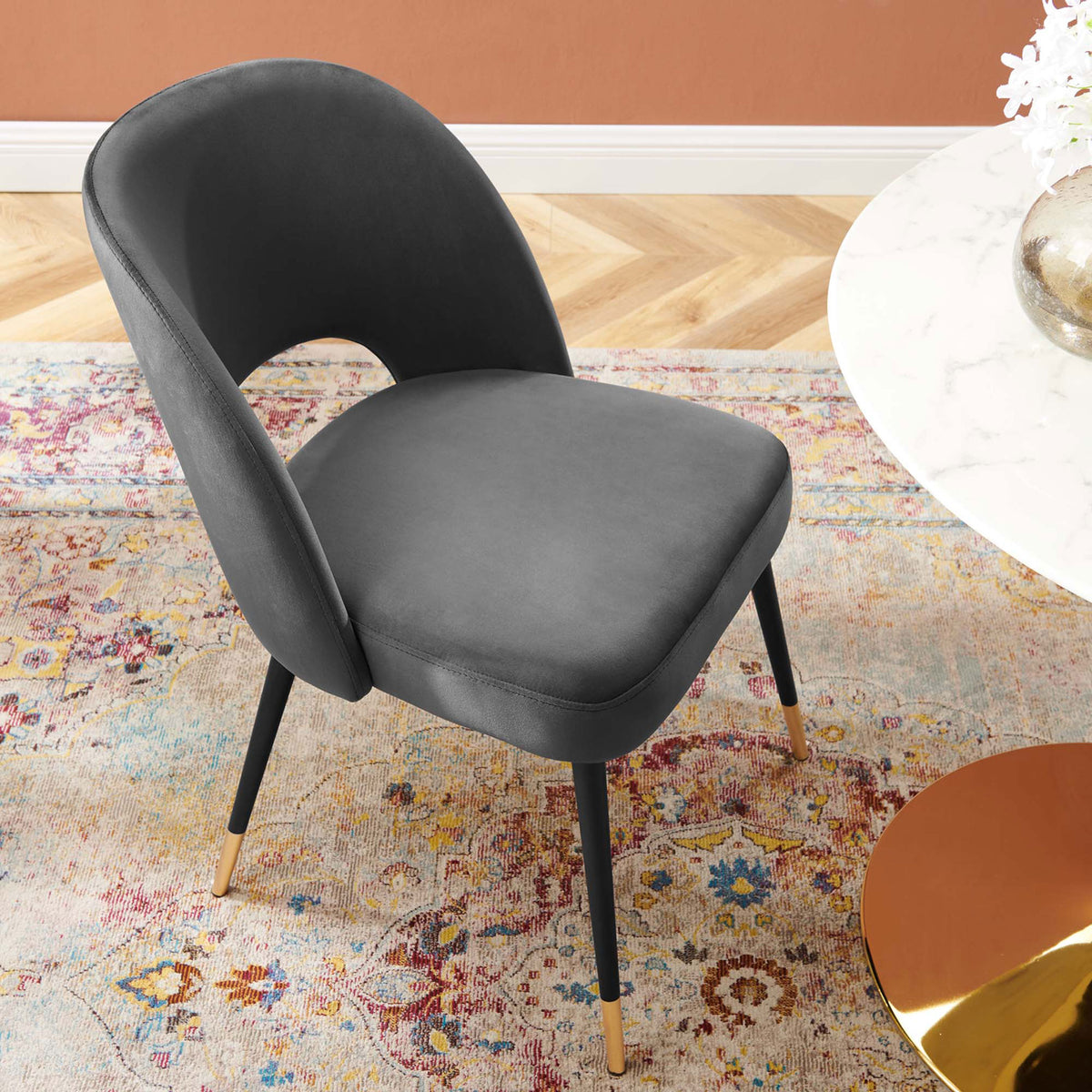 Charcoal velvet dining chair styled at a marble table over a colorful patterned rug. || EEI-4212-CHA || top_angle_room