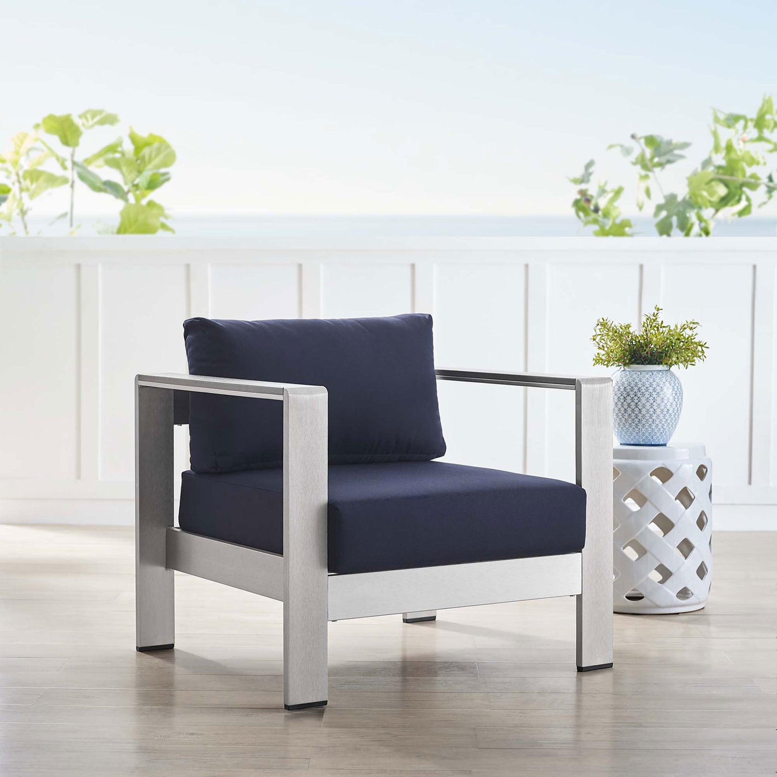 Navy Sunbrella(r) armchair completes a breezy coastal-inspired seating vignette || EEI-4225-SLV-NAV || front_angle_room