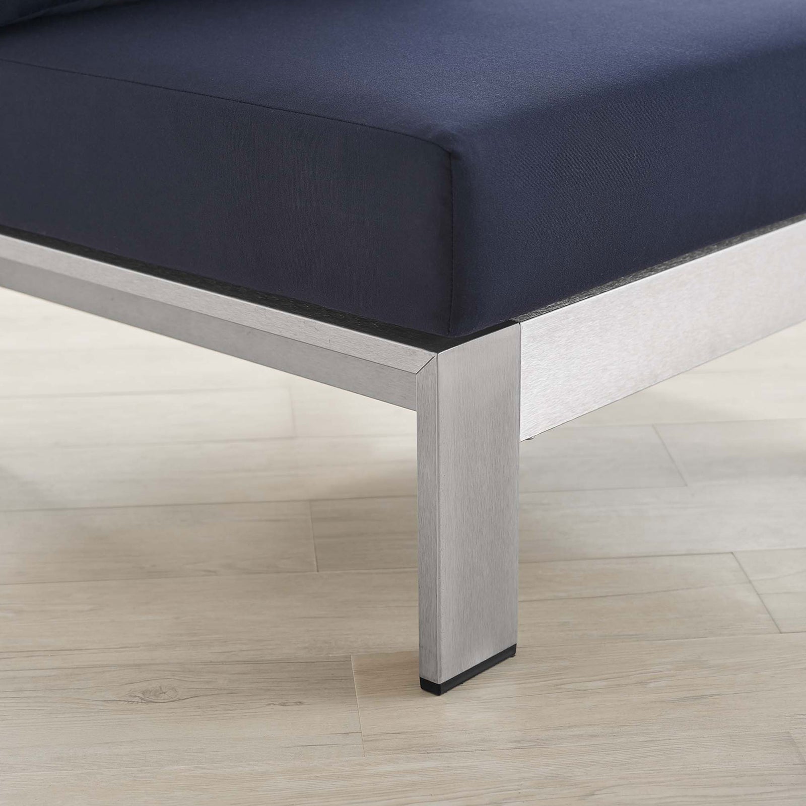 Rich navy Sunbrella(r) fabric and brushed aluminum leg bring contemporary contrast to the deck || EEI-4227-SLV-NAV || detail_room
