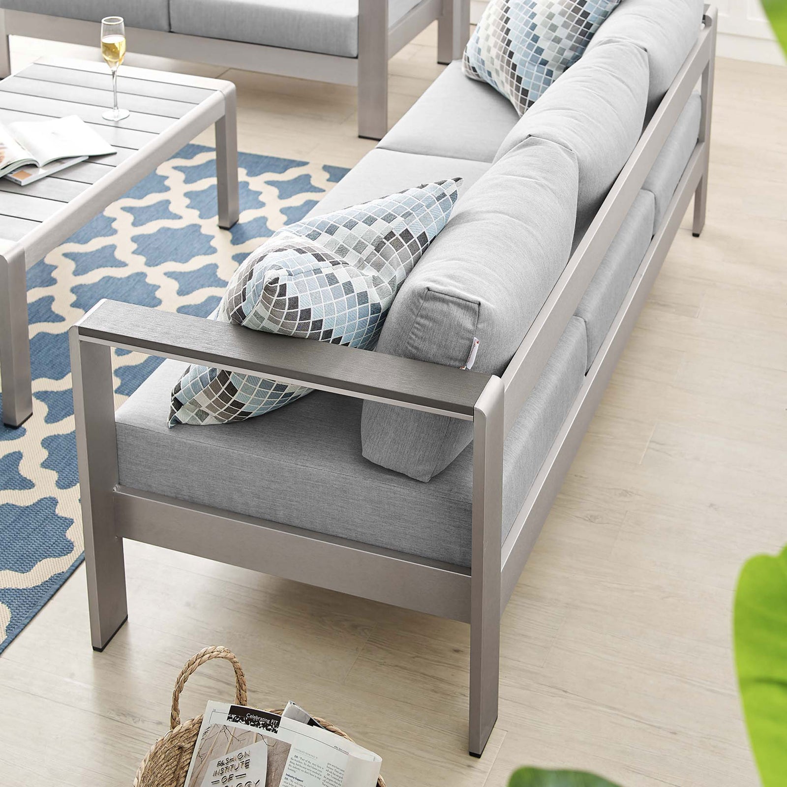 Sofa backs neatly line up with matching lounge chairs and a geometric outdoor rug || EEI-4228-SLV-GRY || back_angle_room