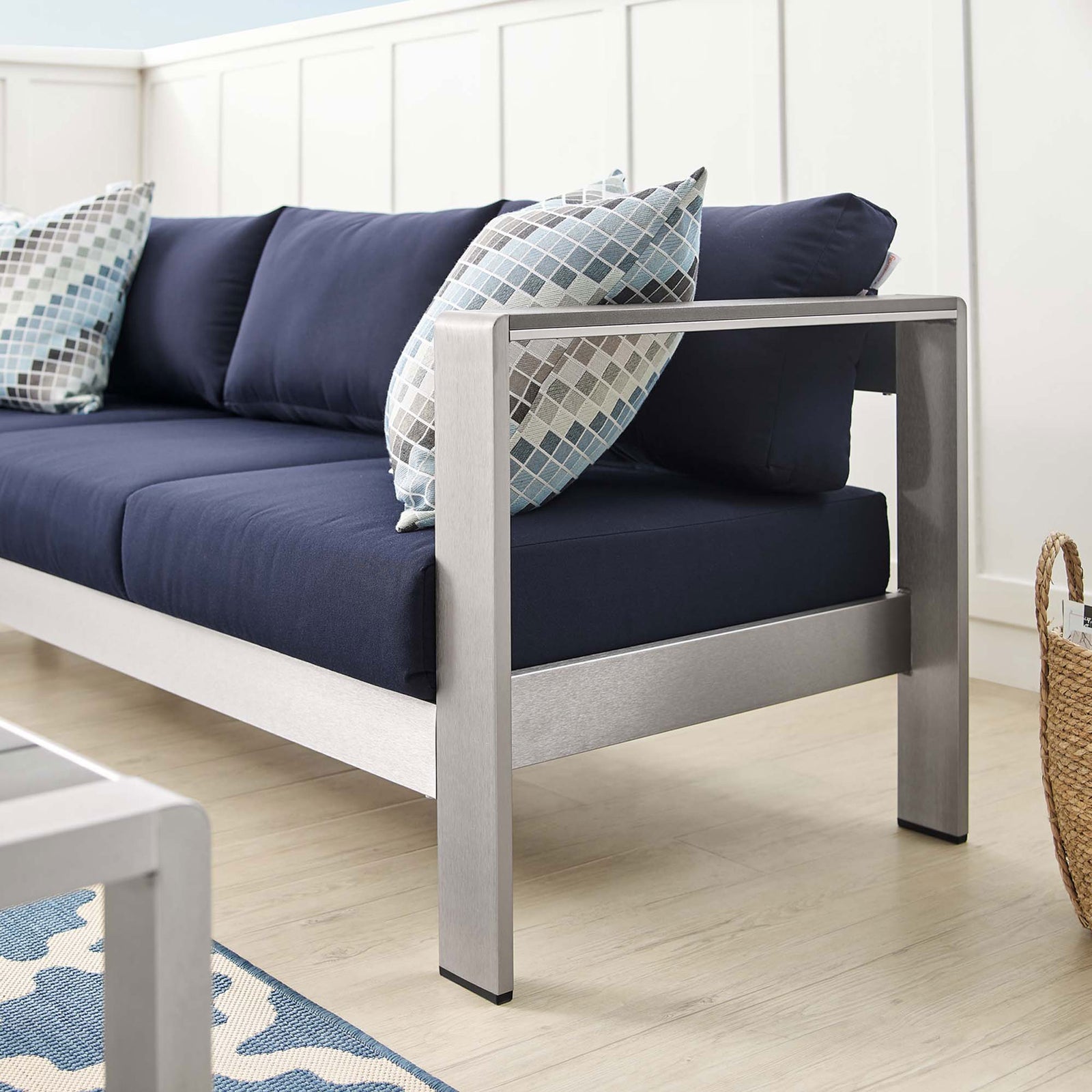 Brushed aluminum arm and plush navy cushions pair with patterned pillows for relaxed outdoor seating || EEI-4228-SLV-NAV || detail_room