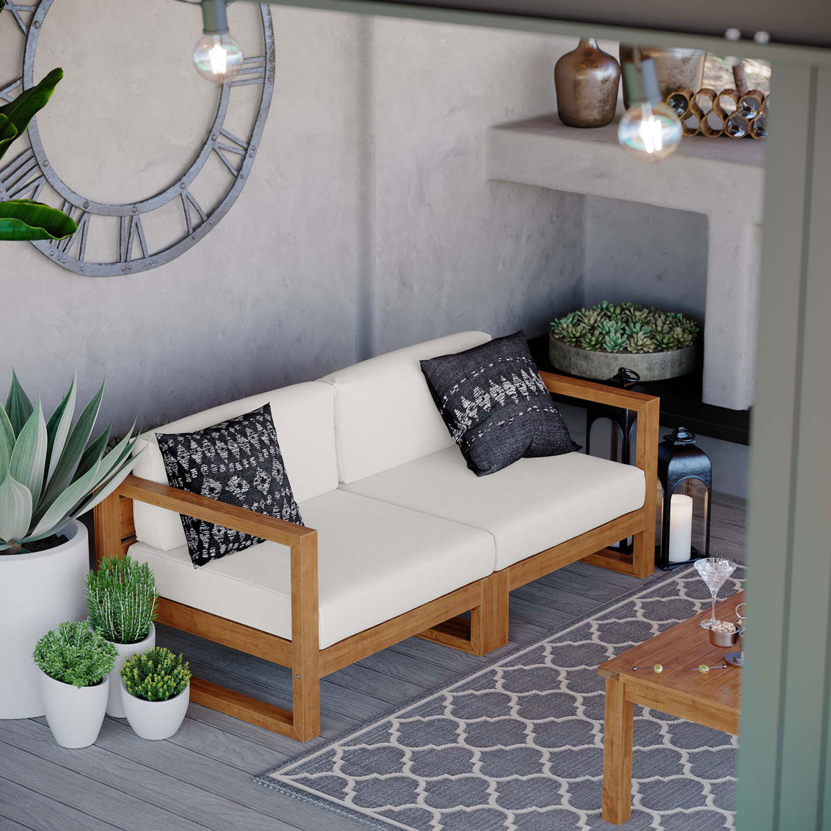 Outdoor teak sectional loveseat with white cushions shown in a modern poolside lounge setting || EEI-4256-NAT-WHI-SET || front_angle_room