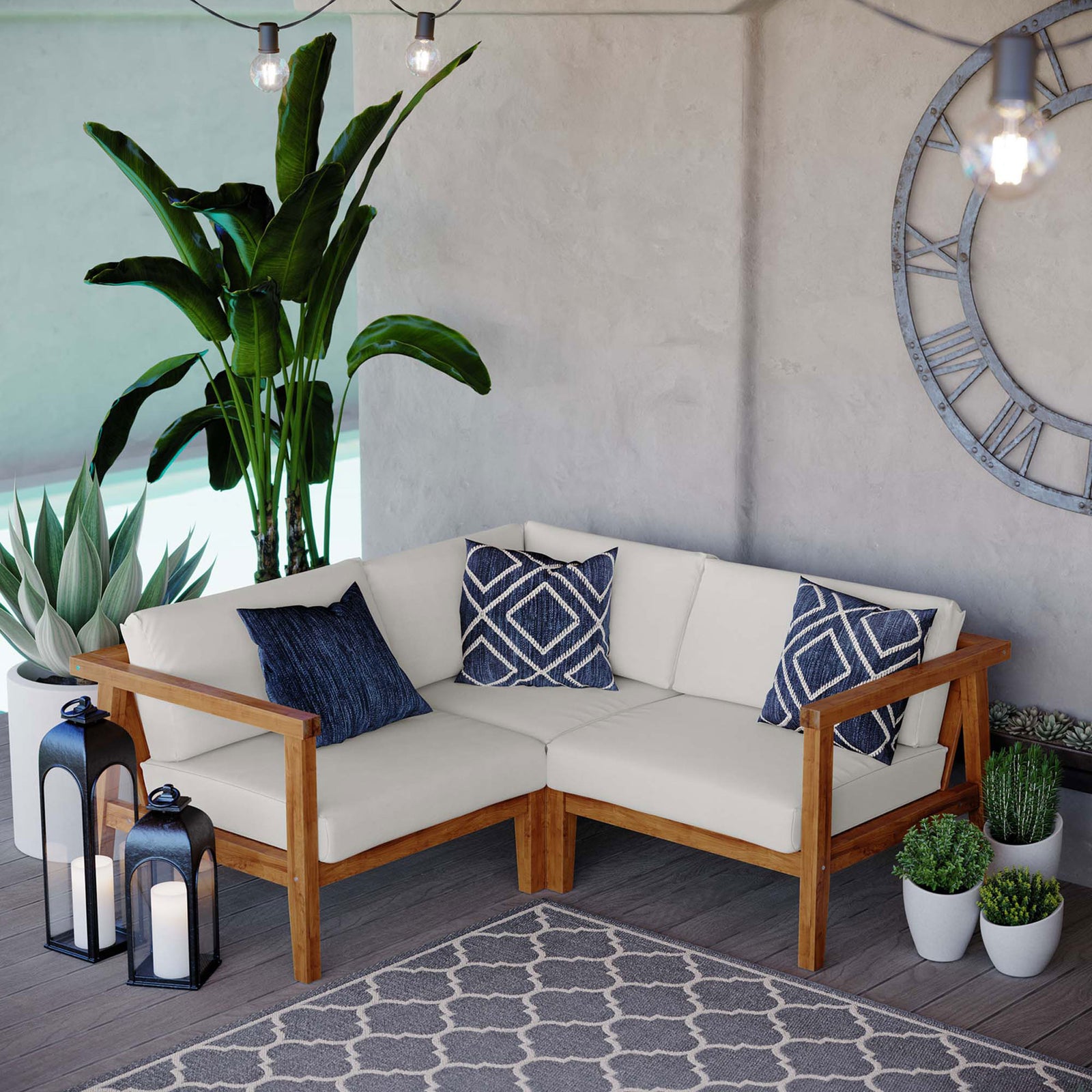Complete teak sectional seating area with white cushions, blue accents, plants, and outdoor rug || EEI-4258-NAT-WHI-SET || front_angle_room