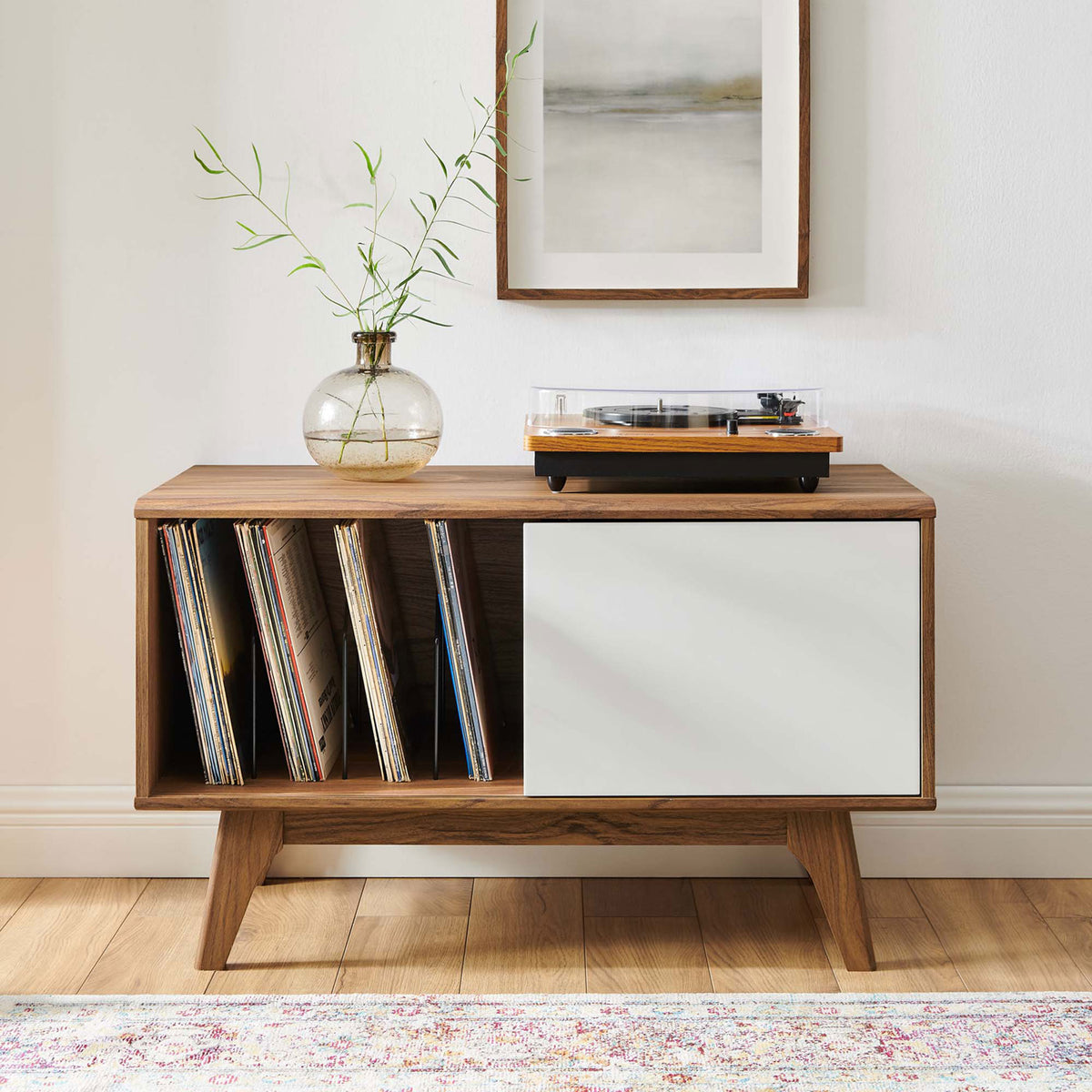 Record display stand holds a turntable and vinyl collection in a bright, modern living space || EEI-4261-WAL-WHI || front_angle_room