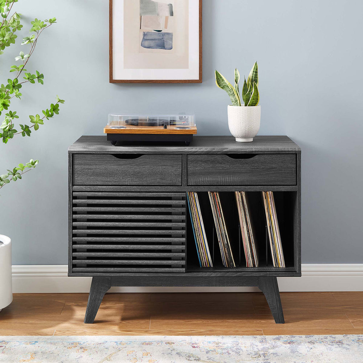 Charcoal vinyl record stand centered in a bright room with wall art, greenery, and space to store albums and media || EEI-4323-CHA || front_room