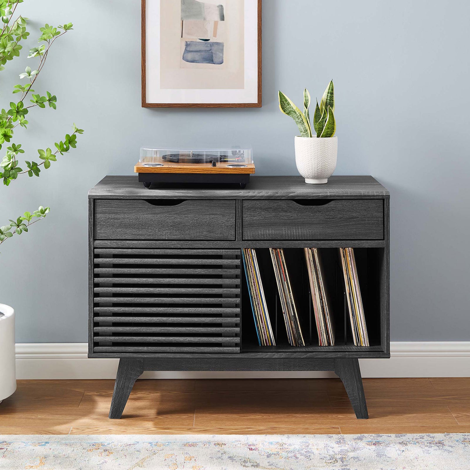 Charcoal vinyl record stand centered in a bright room with wall art, greenery, and space to store albums and media || EEI-4323-CHA || front_room