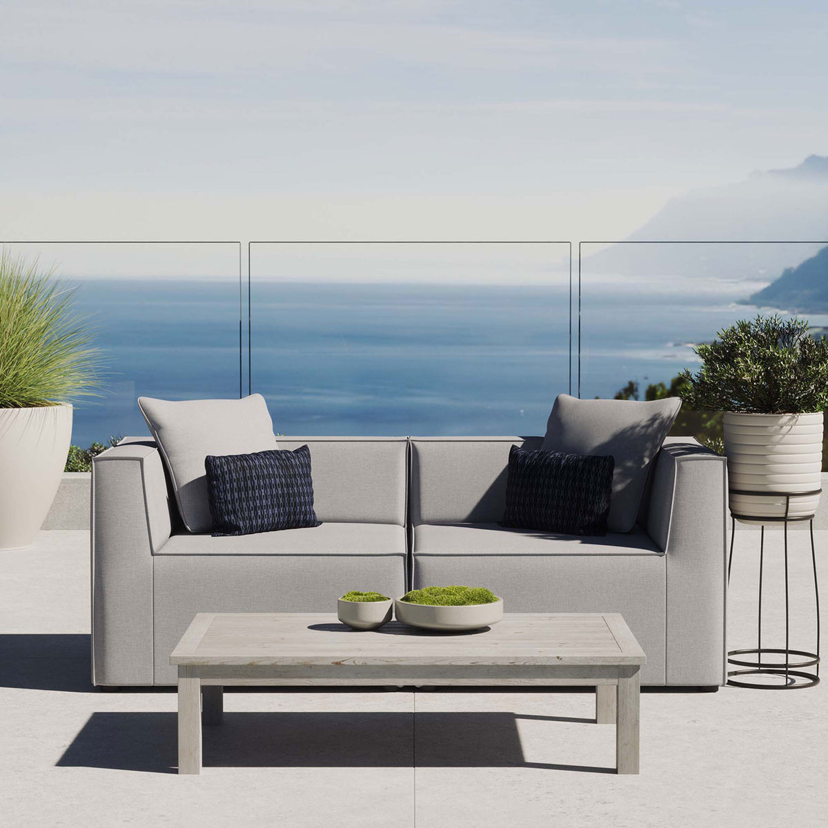 Gray upholstered patio loveseat creating a cozy seating spot overlooking a bright coastal view. || EEI-4377-GRY || front_room
