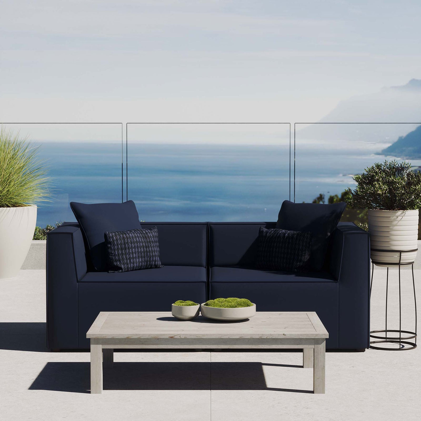 Navy upholstered patio loveseat creating an inviting conversation spot with a sweeping ocean backdrop. || EEI-4377-NAV || front_room