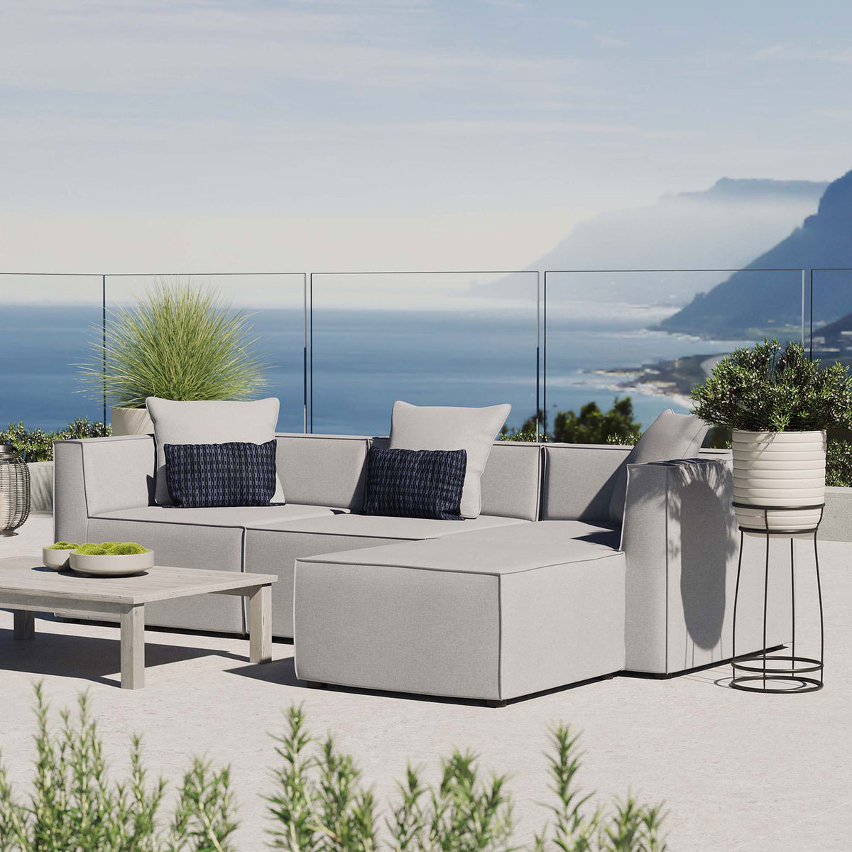 Gray Saybrook sectional styled on a sunny terrace with accent pillows and outdoor greenery || EEI-4380-GRY || front_angle_room