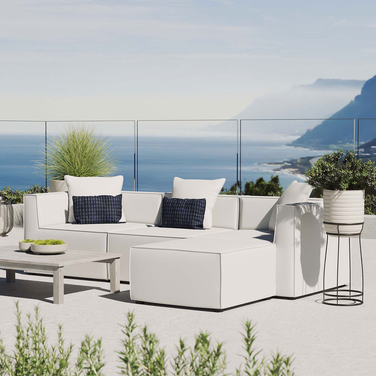 White Saybrook sectional styled on a bright terrace with accent pillows and lush greenery || EEI-4380-WHI || front_angle_room