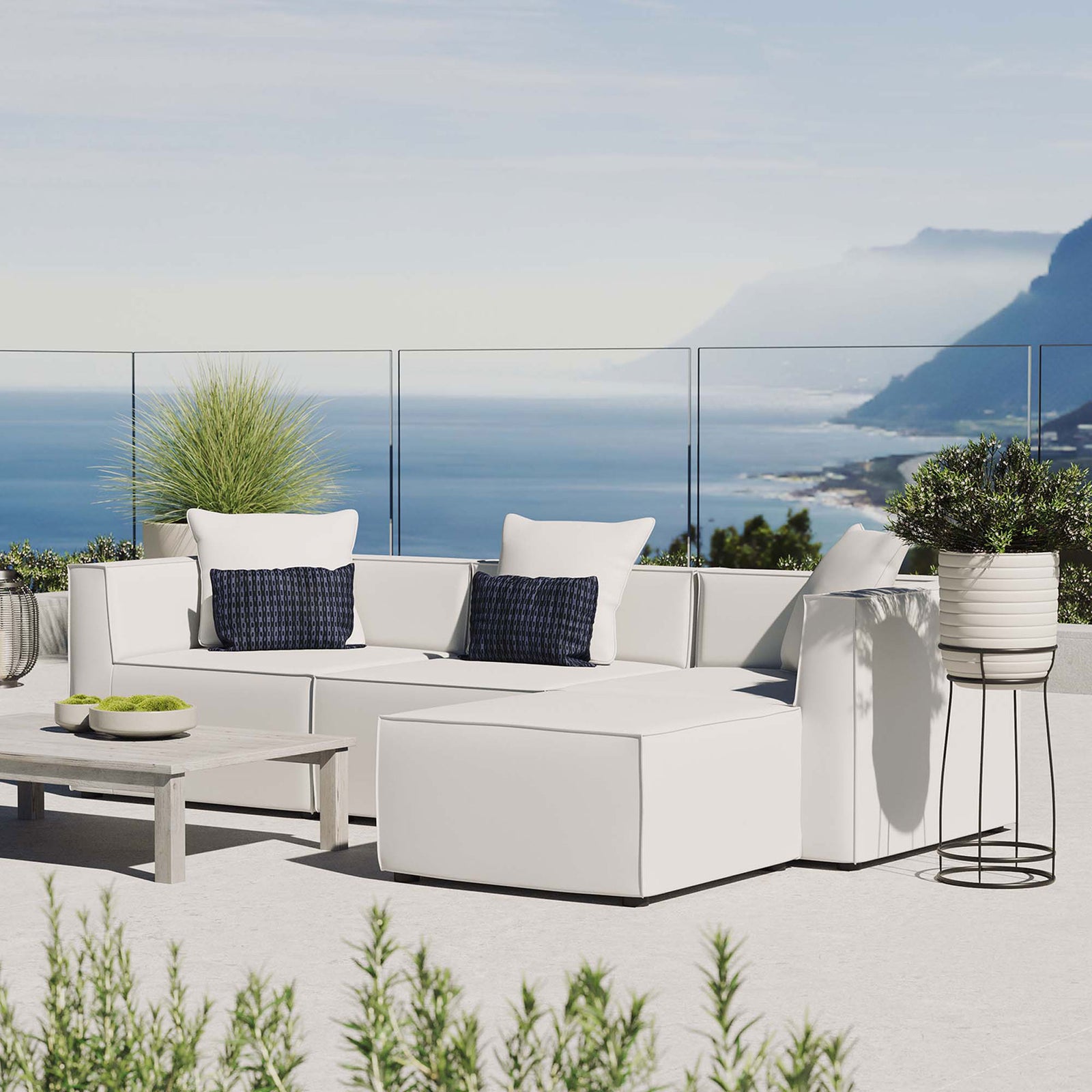 White Saybrook sectional styled on a bright terrace with accent pillows and lush greenery || EEI-4380-WHI || front_angle_room