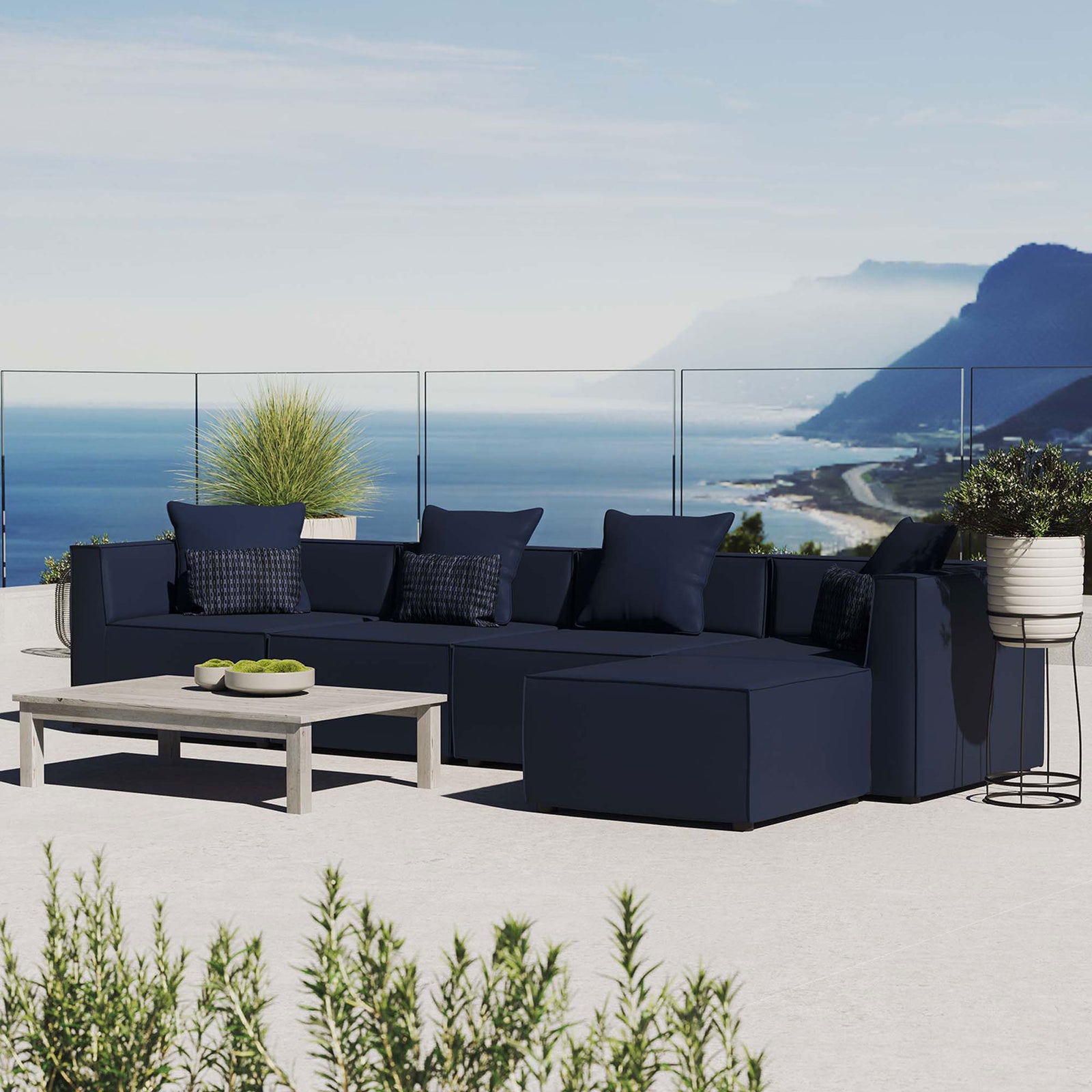 Navy Saybrook outdoor sectional arranged on a sunny coastal patio with accent decor || EEI-4382-NAV || front_angle_room