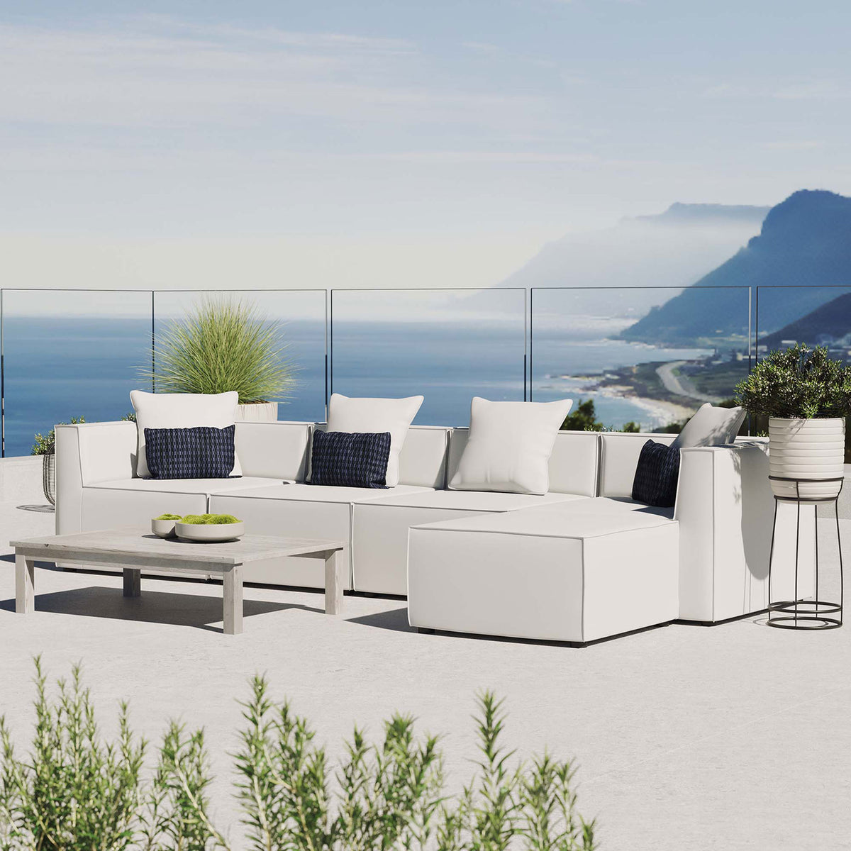 White Saybrook outdoor sectional styled on a bright coastal patio with greenery || EEI-4382-WHI || front_angle_room