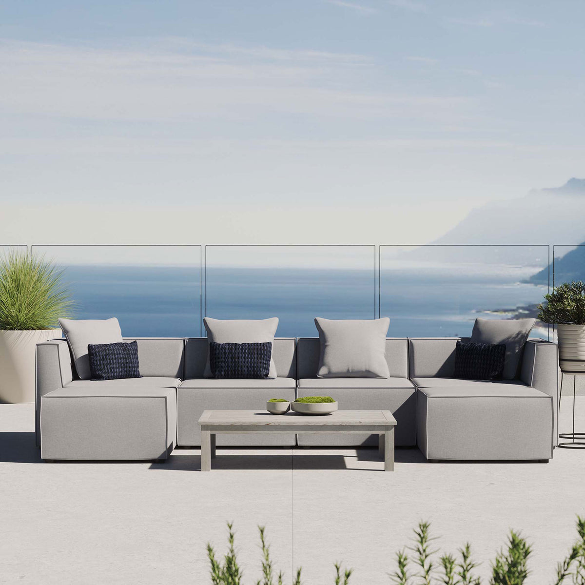 Gray Saybrook outdoor sectional styled on a coastal patio with accent pillows and a modern coffee table. || EEI-4383-GRY || front_room