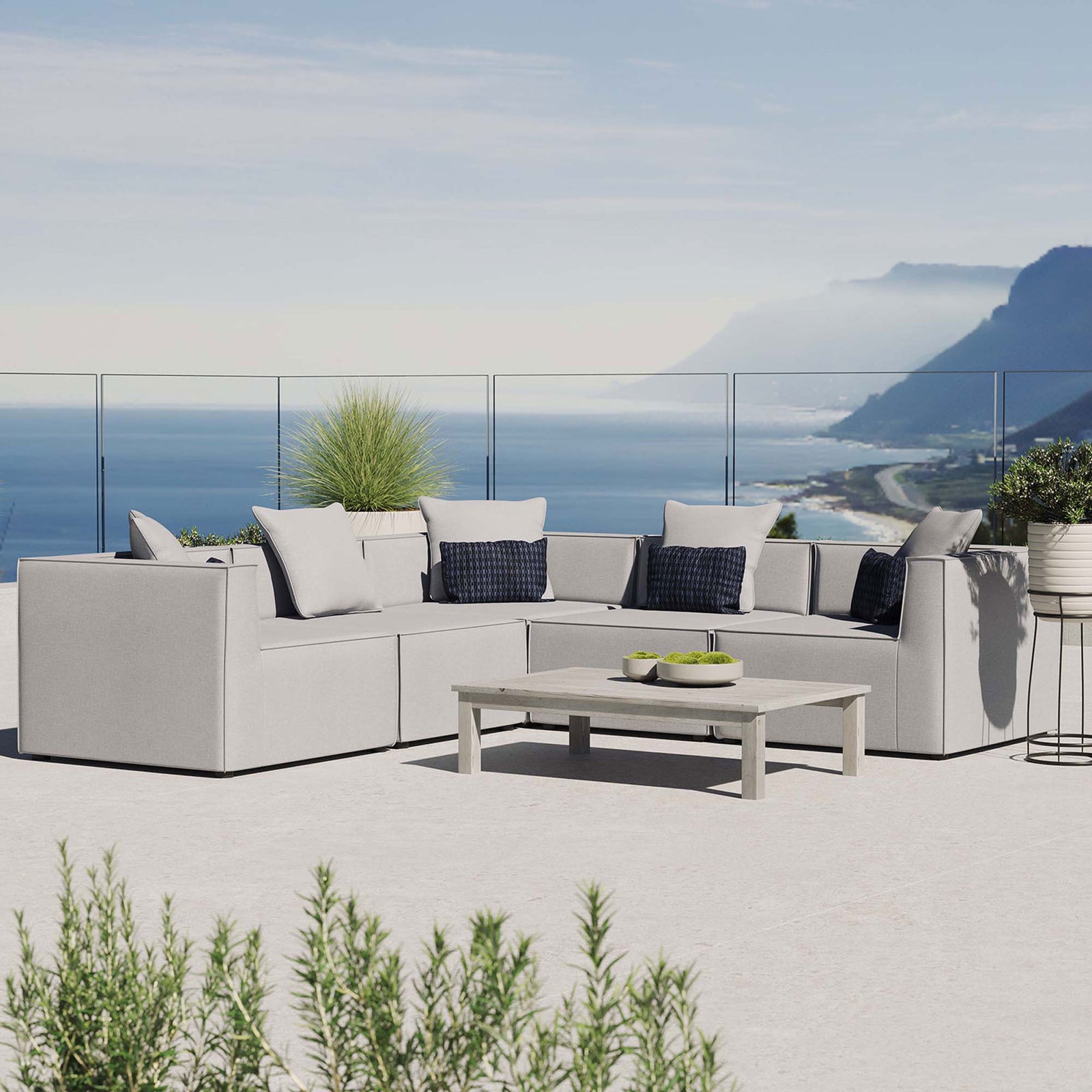 Gray Saybrook sectional styled on a rooftop patio with coastal view and low profile coffee table || EEI-4384-GRY || front_angle_room