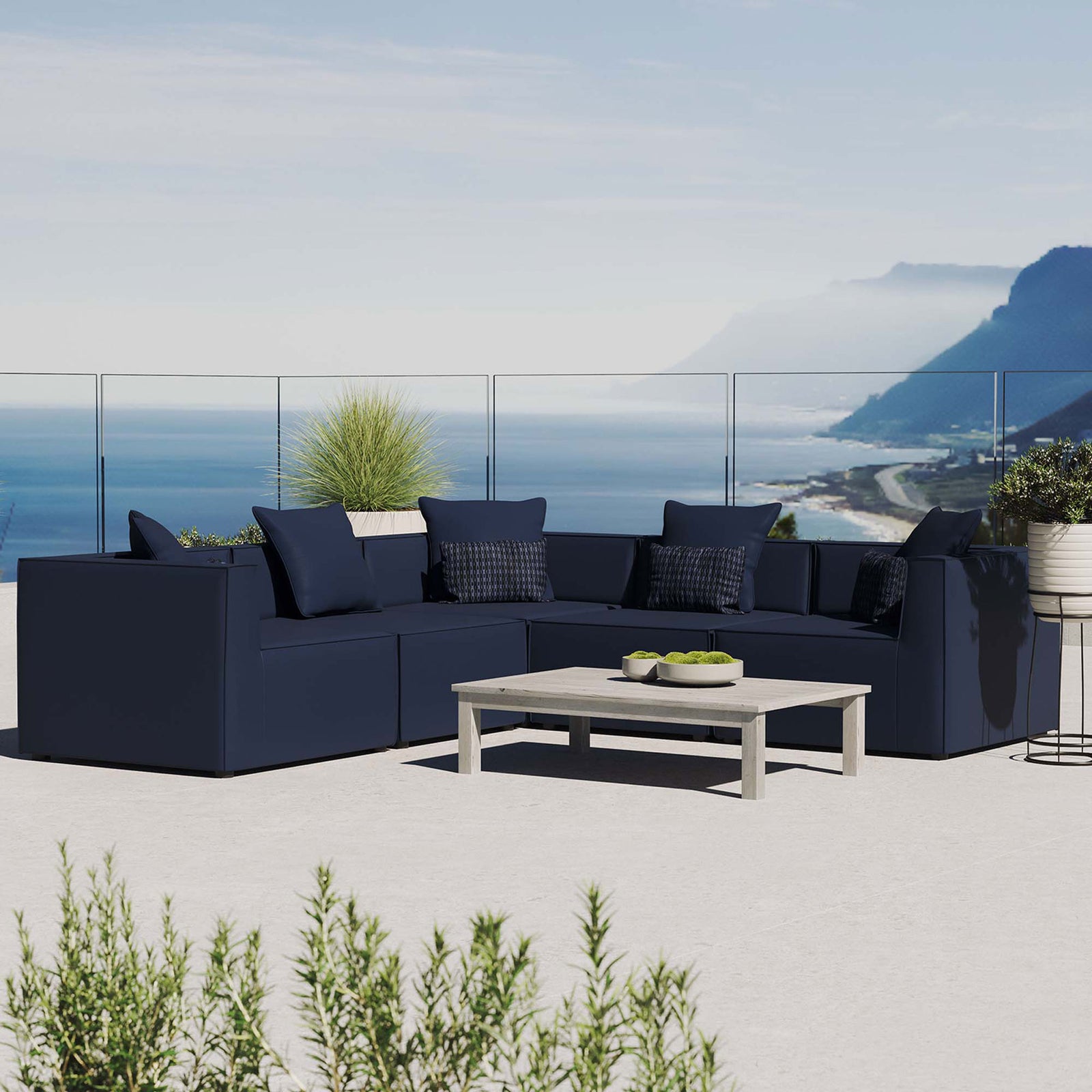 Navy Saybrook sectional styled on a rooftop patio with coastal view and low profile coffee table || EEI-4384-NAV || front_angle_room