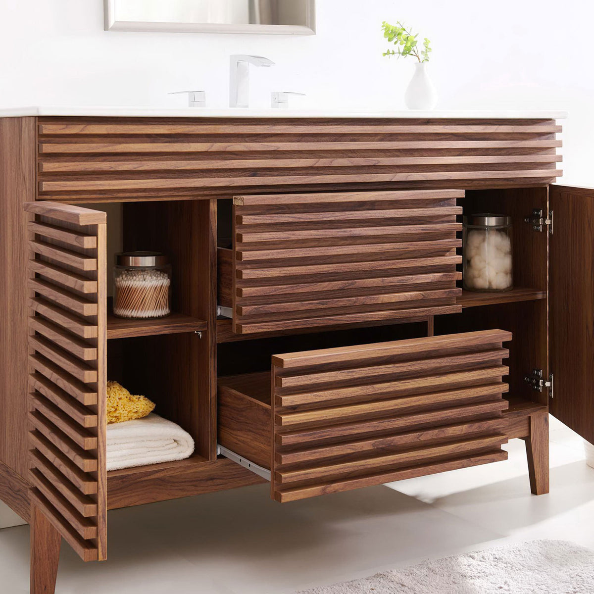 Warm walnut vanity showcases ample storage with open doors and drawers beneath a bright ceramic top. || EEI-4439-WAL-WHI || front_angle_open_room