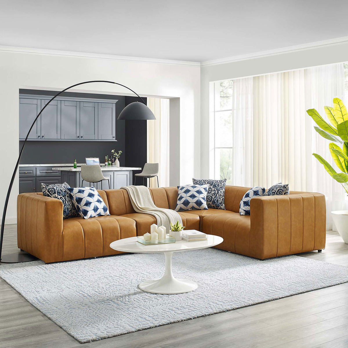 Tan Bartlett vegan leather 4 piece sectional creating a cozy lounge area in a bright open living room || EEI-4519-TAN || front_angle_room