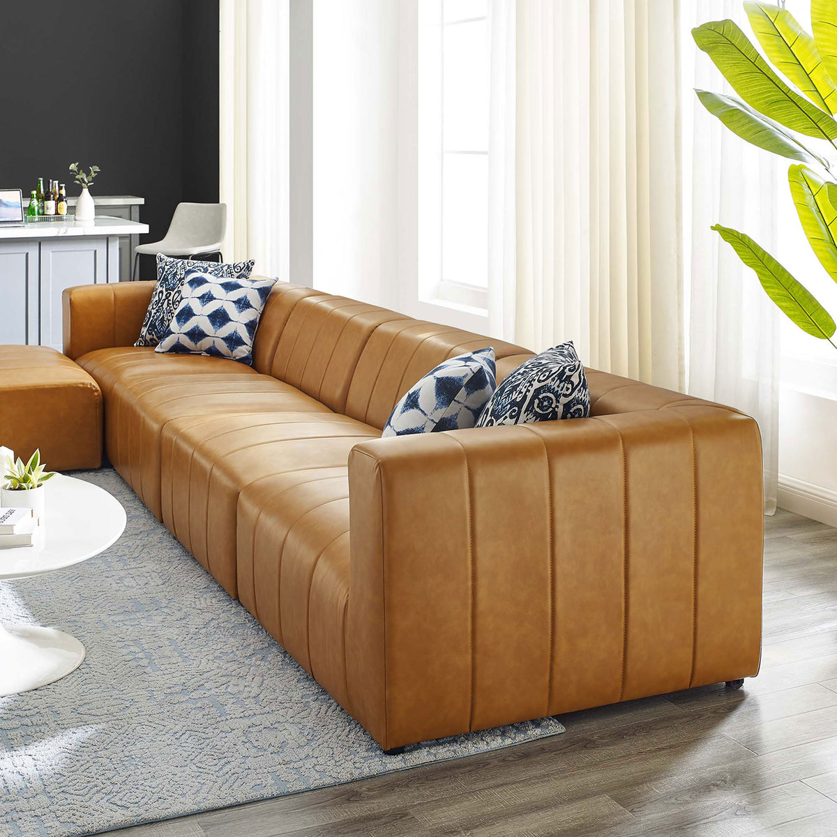 Tan Bartlett vegan leather sectional styled in a bright living room with accent pillows || EEI-4521-TAN || detail_room