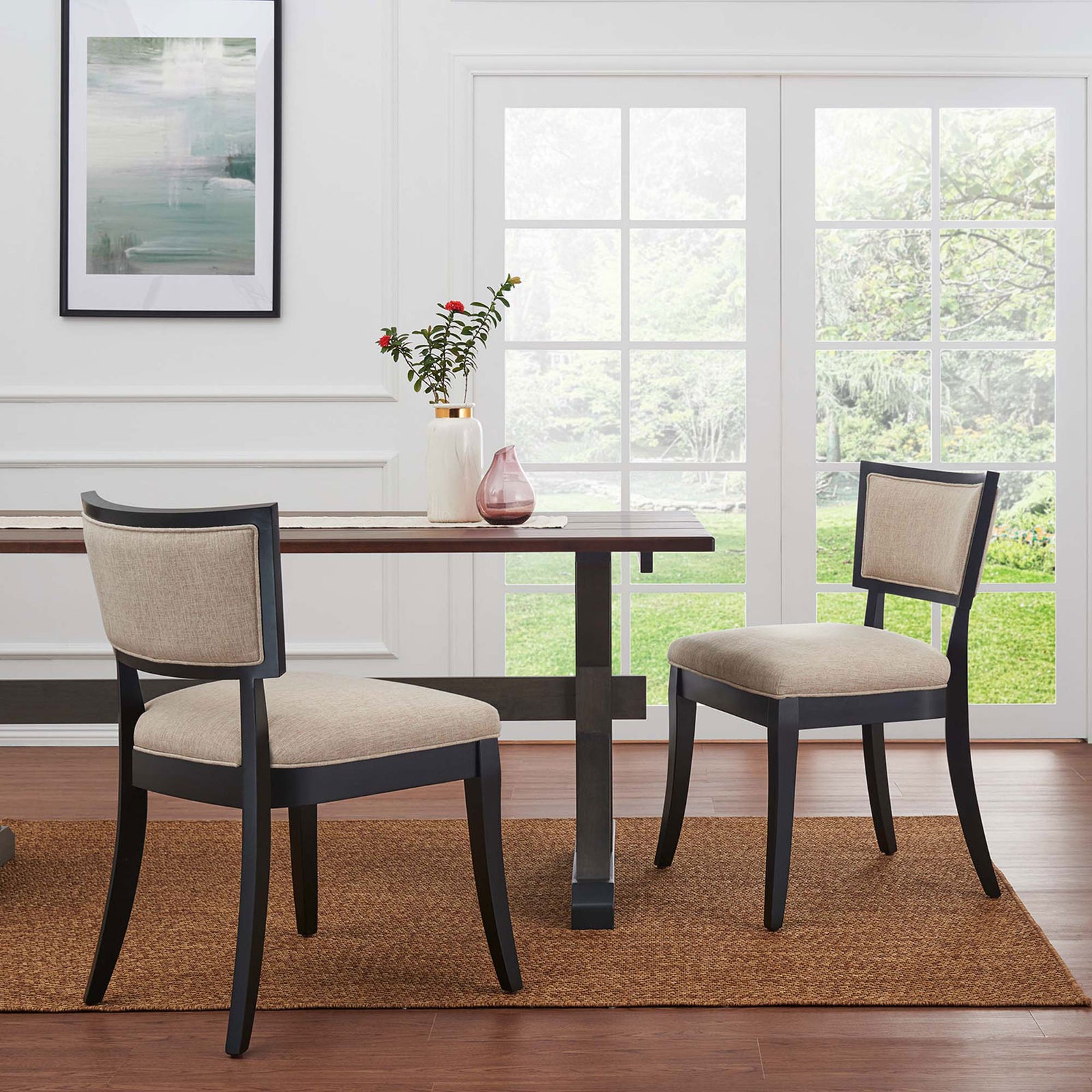 Pair of beige upholstered dining chairs arranged around a modern dining table in a bright room || EEI-4557-BEI || front_angle_multi_room
